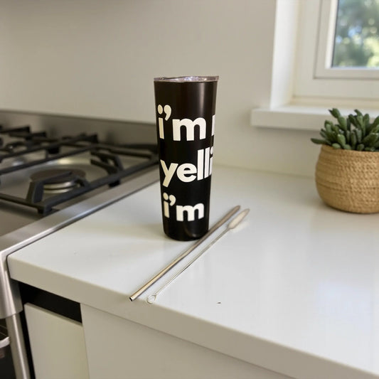 Black tumbler with 'I’m not yelling..I’m Dominican' text on a kitchen counter